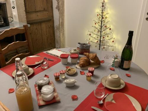 een tafel met een fles wijn en een kerstboom bij Chambres d'Hôtes La Petite Odile in Boersch