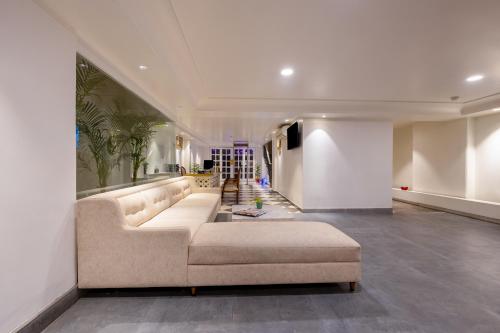 een woonkamer met een grote bank in het midden bij Hotel Pinky Villa - Heritage Boutique Suites- New Delhi in New Delhi