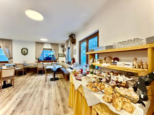een kamer met tafels vol brood en gebak bij B&B Family Accommodation Canazei SKI-IN SKI-OUT in Canazei