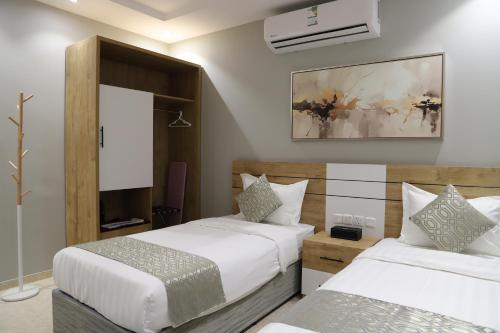 a hotel room with two beds and a mirror at اجنحة نزيل in Tabuk