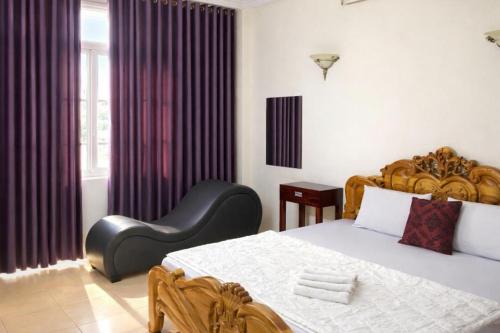 a bedroom with a large bed and a chair at Du Thuyền Hotel Hồ Chí Minh in Ho Chi Minh City