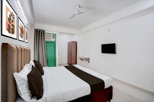 een slaapkamer met een bed en een groene deur bij Collection O by OYO HOTEL DLF PHASE-4 MG ROAD in Gurgaon
