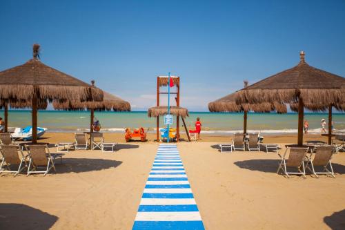a beach with chairs and umbrellas and the ocean at Grand Hotel Don Juan in Giulianova