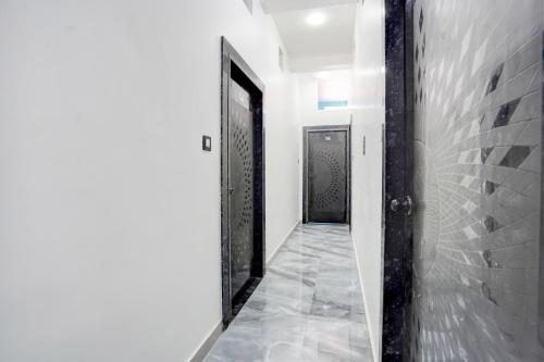 un corridoio con una porta e un pavimento piastrellato di SPOT ON Hotel Omava Inn a Garhā