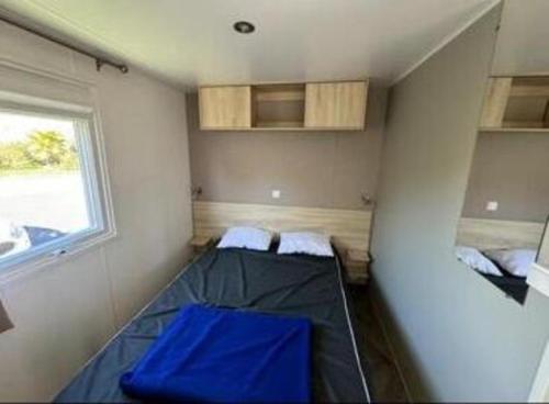 una piccola stanza con due letti e una finestra di Mobil home Oasis Les Palmiers a Valras-Plage