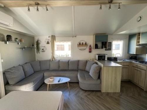 un soggiorno con divano e cucina di Mobil home Oasis Les Palmiers a Valras-Plage