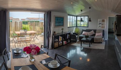 un salon avec une table et un canapé dans l'établissement Maison d'Hôtes Les Petites Terres, à Sainte-Marie de Ré
