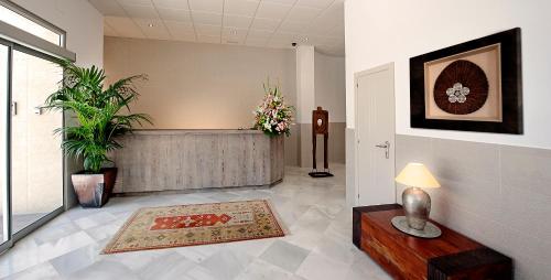 un vestíbulo con una sala de espera con flores en la pared en Hostal Tarifa, en Tarifa