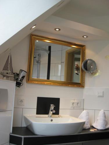 a bathroom with a sink and a mirror at Ferienhaus Wind in Struckum