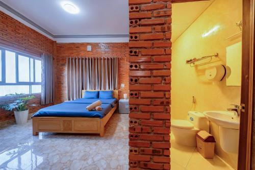 una camera con letto blu e muro di mattoni di Dalat Note Hostel a Da Lat