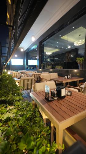 a restaurant with a wooden table and chairs at Al jadriya Palace in Baghdad