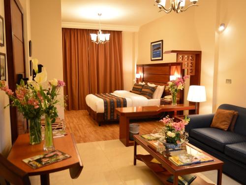 a hotel room with a bed and a living room at Comfort Hotel Suites in Amman