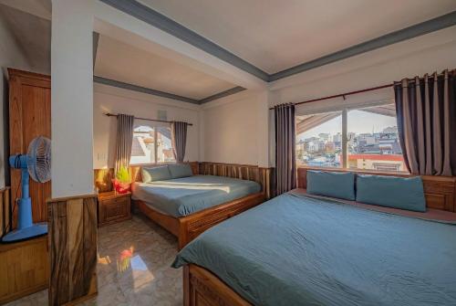 una camera da letto con due letti e una finestra di Dalat Note Hostel a Da Lat