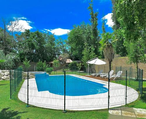 a fence around a swimming pool in a yard at Shangri la - Casa y Pileta Privada in Mendoza