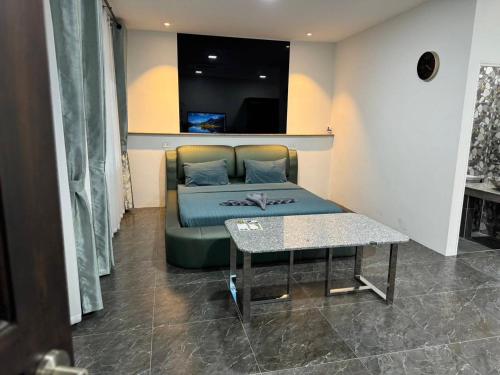 een bed in een kamer met een tafel en een bank bij M-Resort Pathum-thani Thailand in Ban Khlong Sam Wa (3)