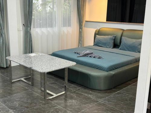 een bed en een tafel in een kamer bij M-Resort Pathum-thani Thailand in Ban Khlong Sam Wa (3)