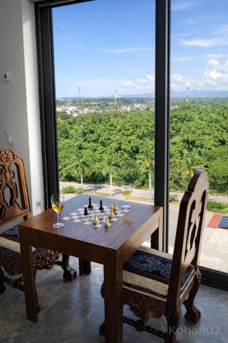 a table with a chess board and wine glasses in front of a window at Puerto Vallarta Centro de convenciones Aeropuerto in Puerto Vallarta