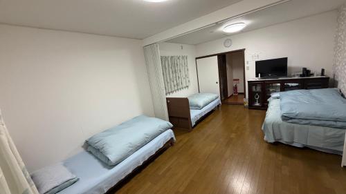 a hotel room with two beds and a television at 薫樹xiang po po inn in Kyoto