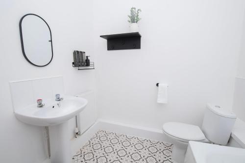 a bathroom with a sink and a toilet and a mirror at Amber Serviced Rooms - Free parking Self Check-In with access to shared kitchen in Hull