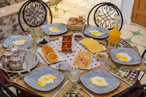 a table with plates of breakfast food on it at Riad Cherifa Breakfast and Jacuzzi Terrace in Marrakesh