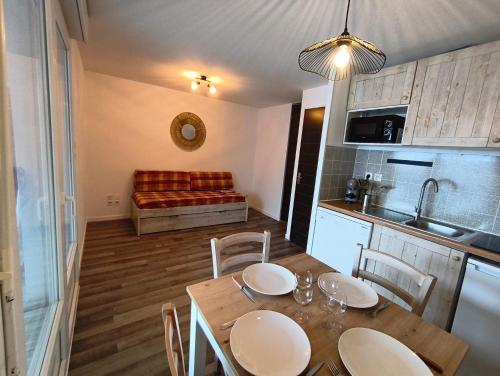 eine Küche und ein Esszimmer mit Tisch und Stühlen in der Unterkunft Studio Grand Balcon Montagne Ski et Randos in Luz-Saint-Sauveur
