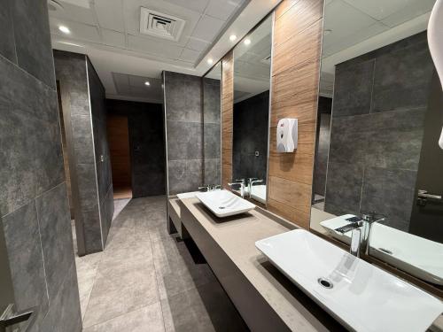 een badkamer met twee wastafels en een grote spiegel bij Canal View Studio AG Tower in Dubai