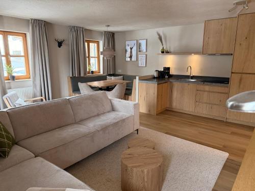 a living room with a couch and a kitchen at Chalet Zur Rose in Berwang bij de piste in Berwang