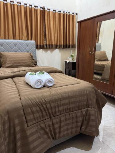 a bedroom with a bed with two towels on it at Rumah Cahaya Syariah Peaceful Family Home in Rampal