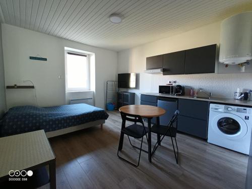 ein kleines Zimmer mit einem Bett und einem Tisch darin in der Unterkunft Studio 1 Classe 2, Fibre, Netflix in Moirans-en-Montagne