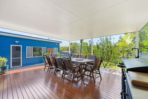 a dining room with a table and chairs on a deck at The Blue Cottage in Ulladulla