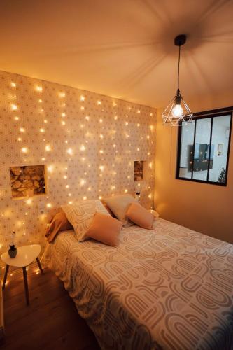 een slaapkamer met een bed met verlichting aan de muur bij Ancien Cloître rénové - Hyper centre - T2 de 50m2 in Mont-de-Marsan