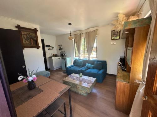 un soggiorno con un divano blu e un tavolo di Quincho la Beli a Chillán