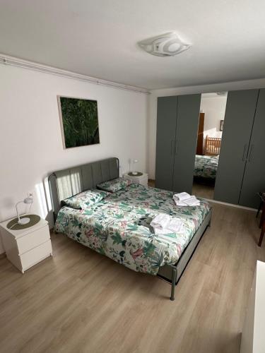 a bedroom with a bed with a green comforter at Appartamento Medán in Mezzano