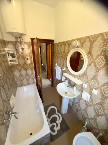 a bathroom with a tub and a sink and a toilet at Sperlonga Center Home in Sperlonga