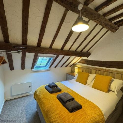 a bedroom with a large bed with yellow sheets at Barn Retreat with Valley Views & Onsite Dog Field in Bryn-crug