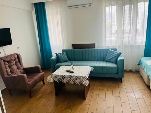 een woonkamer met een blauwe bank en een tafel bij Şirin Apartrooms in Pamukkale