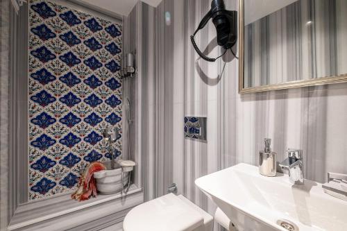 een badkamer met een toilet en een blauwe en witte tegelmuur bij Taksim Garden House in Istanbul