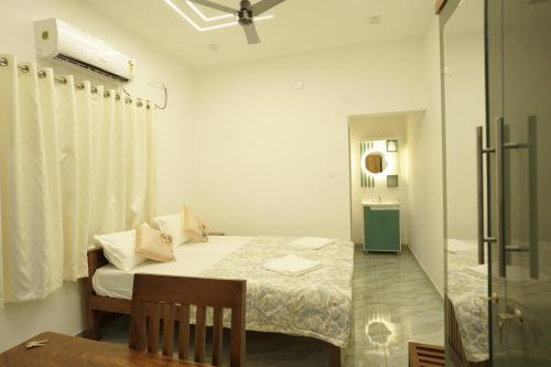 a small room with a bed and a bathroom at Mermaid Marari in Mararikulam