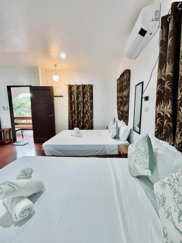 a hotel room with two beds and a window at LUZVILLE Transient House - Port Barton in Itaytay