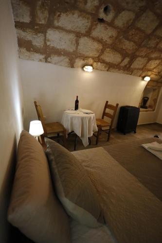 ein Zimmer mit einem Tisch und einer Flasche Wein darauf in der Unterkunft SternesVillage, Middle Ground Floor in Stérnai