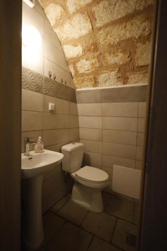 ein Badezimmer mit Toilette und Waschbecken in der Unterkunft SternesVillage, Middle Ground Floor in Stérnai