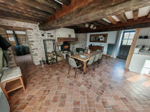 Gîte Anmany في Quarré-les-Tombes: غرفة معيشة كبيرة بها طاولة ومدفأة