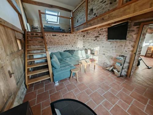 Gîte Anmany في Quarré-les-Tombes: غرفة معيشة مع أريكة زرقاء وتلفزيون