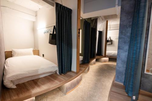 a bedroom with a bed in a room with curtains at Wa Hostel in Tokyo