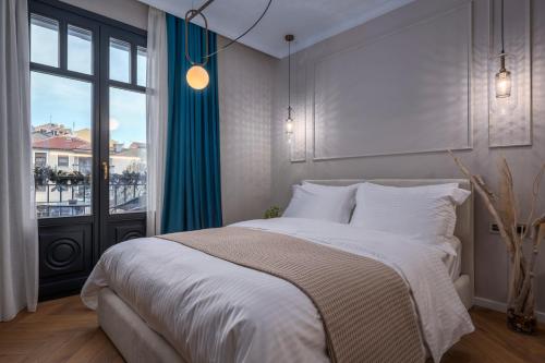 une chambre avec un lit et une grande fenêtre dans l'établissement Mountain Pine Luxury Suites, à Flórina