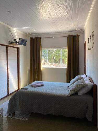 een slaapkamer met een groot bed voor een raam bij FamilySpace in Búzios