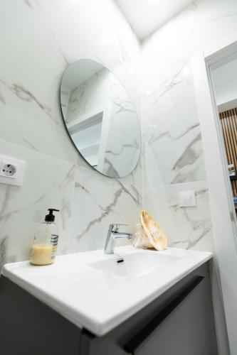 a white bathroom with a sink and a mirror at Go-Vi Gozar en Vitoria in Vitoria-Gasteiz