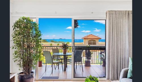 a room with a balcony with a view of the ocean at Shingley Beach Retreat - Ocean Views Apartment in Airlie Beach