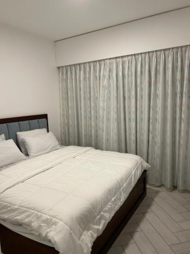 een slaapkamer met een groot bed en een gordijn bij Azure in Aqaba