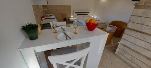 a white table with two glasses and oranges on it at Vaso & Viktor Apartment in Kotor